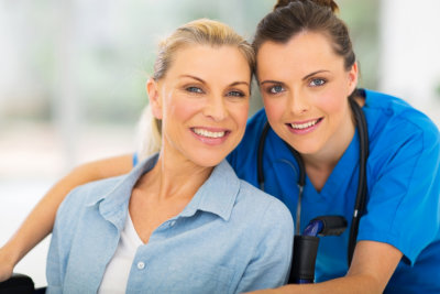 nurse and woman in wheelchair smiling